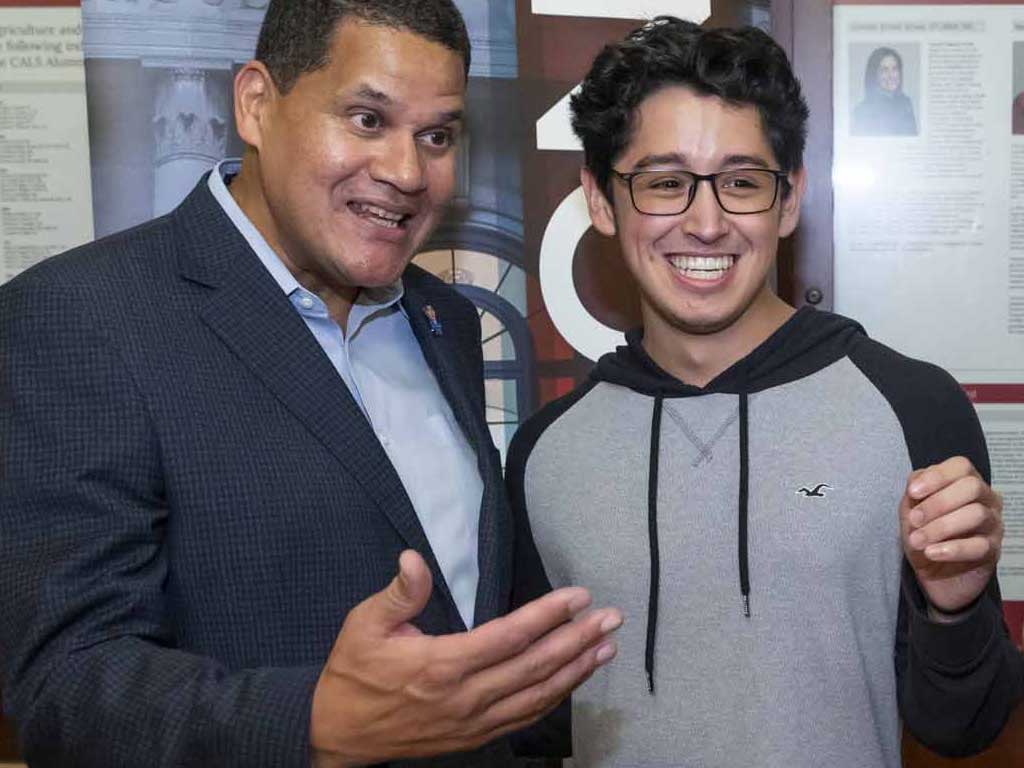 Reggie Fils-Aimé, a Dyson alumni, poses with a student.